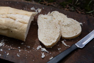 A piece of wheat bread for breakfast cut on a wooden board and a knife