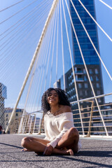 African american young woman in the city, portrait of a young woman sitting on a bridge
