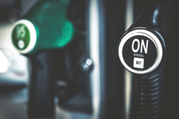 Diesel gasoil pump gun on gas station closeup. Car tank petroleum