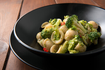 Piatto di deliziose orecchiette condite con broccoli e peperoncino, cibo italiano 