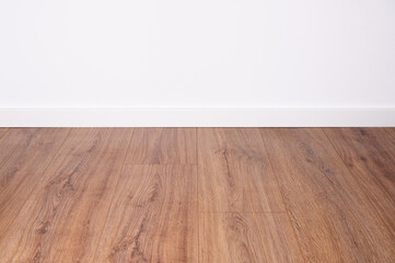 dark oak laminate with white baseboard and white wall as background for design co