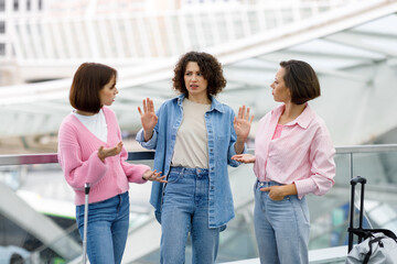 Portrait Of Three Young Females Arguing At Airport About Forgotten Tickets