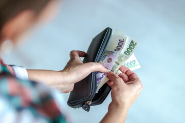 Woman counting banknotes in wallet