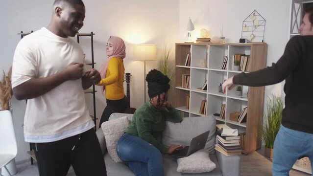 Students relax. Happy friends. Campus routine. Cheerful diverse men and women involving female to have fun in spite of study in light room interior.