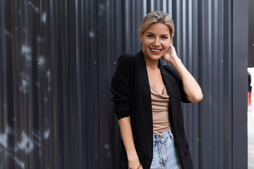 woman office employee flirts against the background of a gray wall in the office