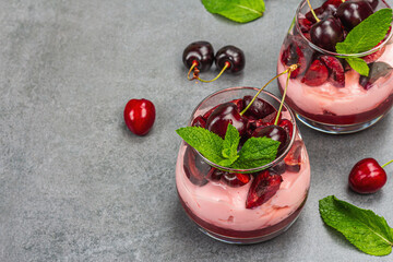 Delicious Italian dessert panna cotta with sweet cherry sauce, fresh berries and mint leaves