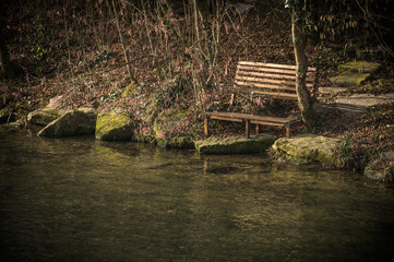 Holzbank an Flussufer mit kahlen B&auml;umen an der Ermsm&uuml;ndung in Neckartenzlingen