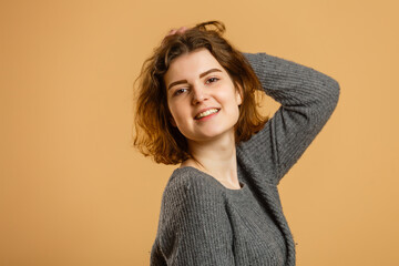 Obraz premium Close up portrait of young happy woman on beige background