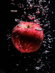 red apple falling in water