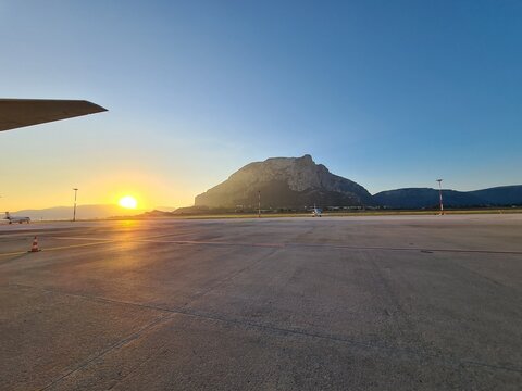 evocative image of the sunrise on an airport runway
