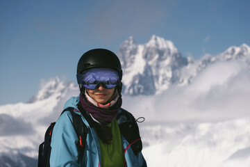 Fototapeta na wymiar Face portrait of Snowboarder female beautiful mountain peaks covered with snow on background