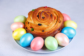 Craffin (Cruffin) with raisins and candied fruits. Traditional Easter Bread Kulich and painted eggs on a gray background. Easter Holiday. Close-up, selective focus.