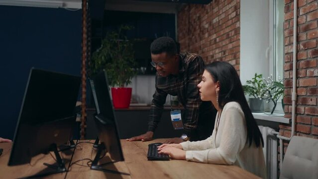 modern loft office, black man and caucasian woman programmers and data analyst working