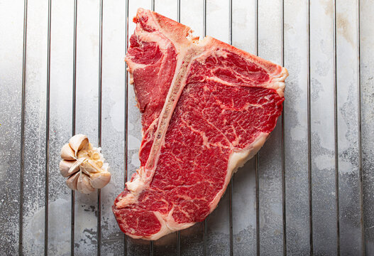 Raw beef T-bone steak with garlic