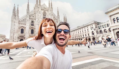 Wandcirkels tuinposter Happy couple taking selfie in front of Duomo cathedral in Milan, Lombardia - Two tourists having fun on romantic summer vacation in Italy - Holidays and traveling lifestyle concept © Davide Angelini