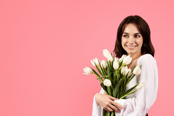 Celebrate holiday, birthday at spring. Glad young european woman with bouquet of white tulips