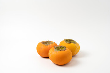 Hard and sweet persimmons on a white background