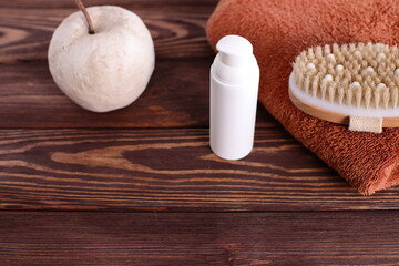 Brush for dry massage on wooden table with towel, lifestyle staging