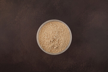 Soy Protein isolate in transparent plastic box, top view. Pure powder isolated from soybean used in...