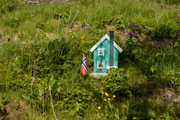 Miniature wooden house with the Norwegian flag. The concept of buying a house or apartment....