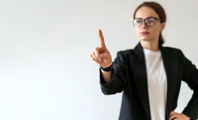 Young adult woman in glasses touching virtual interface, infographic, screen with her hand.