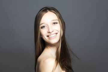 happy positive brunette girl studio portrait against gray background...