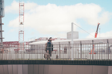 Obraz premium Two young elegant businessmen walking outdoors together in the streets with design construction of modern building