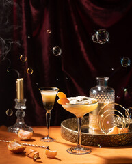 Refreshing orange cocktail with tangerines,liquer,tonic,with candle,bubbles,burgundy,velvet curtain...