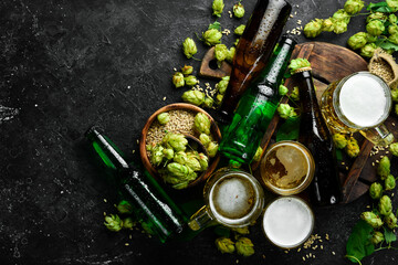 Beer banner. A collection of alcoholic beer in bottles and glasses on a black stone background.