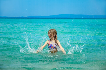 happy child at sea in greece plays in nature