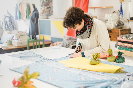 Woman cutting fabric with scissors