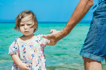 Fototapeta na wymiar hands of happy parent and child at sea greece background