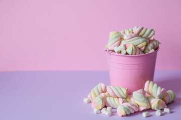 Marshmallows. Chewing candy close-up on a pink background. Dessert of sweet dishes in a pink bucket. Pastel colors. A copy of the text space.