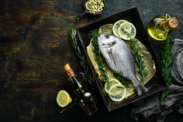 Raw dorado fish is ready for cooking. On a dark table. Top view.