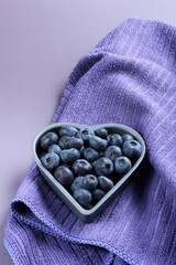 Fresh blueberries in a heart-shaped bowl.