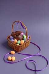 Chocolate bunny and candy eggs in an antique basket, with space for text.
