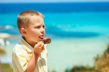 A Happy child boy with ice cream by the sea in nature in the park journey