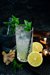 A cooling drink. Lemonade with lemon, tonic with ice and mint in a glass. Cocktails. Bar menu.