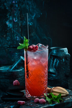 A cooling drink. Raspberry lemonade with tonic, ice and mint in a glass. Cocktails. Bar menu.