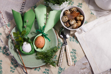 Festive Easter table setting with green napkin Easter Bunny and quail eggs.
