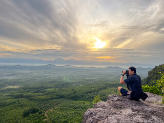 Naklejka premium The photographer sits and looks at the sea of clouds. in Nakhon Si Thammarat Province