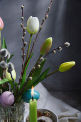Easter bouquet of white tulips and pussy willow on gray background, table decoration detail.