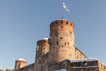 Olavinlinna is under blue sky on a sunny winter day