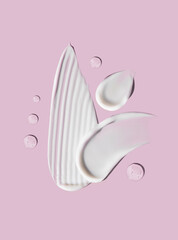 cosmetic smears cream texture on pastel pink background	
