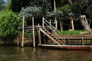 Fototapeta premium Canoe tied up in a wooden dock in the Tigre delta, in Buenos Aires, Argentina