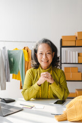 Elderly Asian business woman home office SMEs owner of online clothing store. and fashion designer, social media influencer