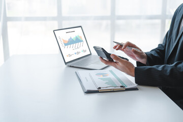 Young handsome asia business man in formal suit working with monthly report balance sheet and...