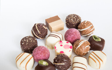 Chocolate pralines truffles with empty space for text.
Selection round truffles confection design for Birthday gift. Luxury candies in white background. Assortment of colorful milk chocolate with nuts