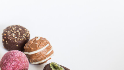 Chocolate pralines truffles with empty space for text.
Selection round truffles confection design for Birthday gift. Luxury candies in white background. Assortment of colorful milk chocolate with nuts