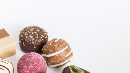 Chocolate pralines truffles with empty space for text.
Selection round truffles confection design for Birthday gift. Luxury candies in white background. Assortment of colorful milk chocolate with nuts